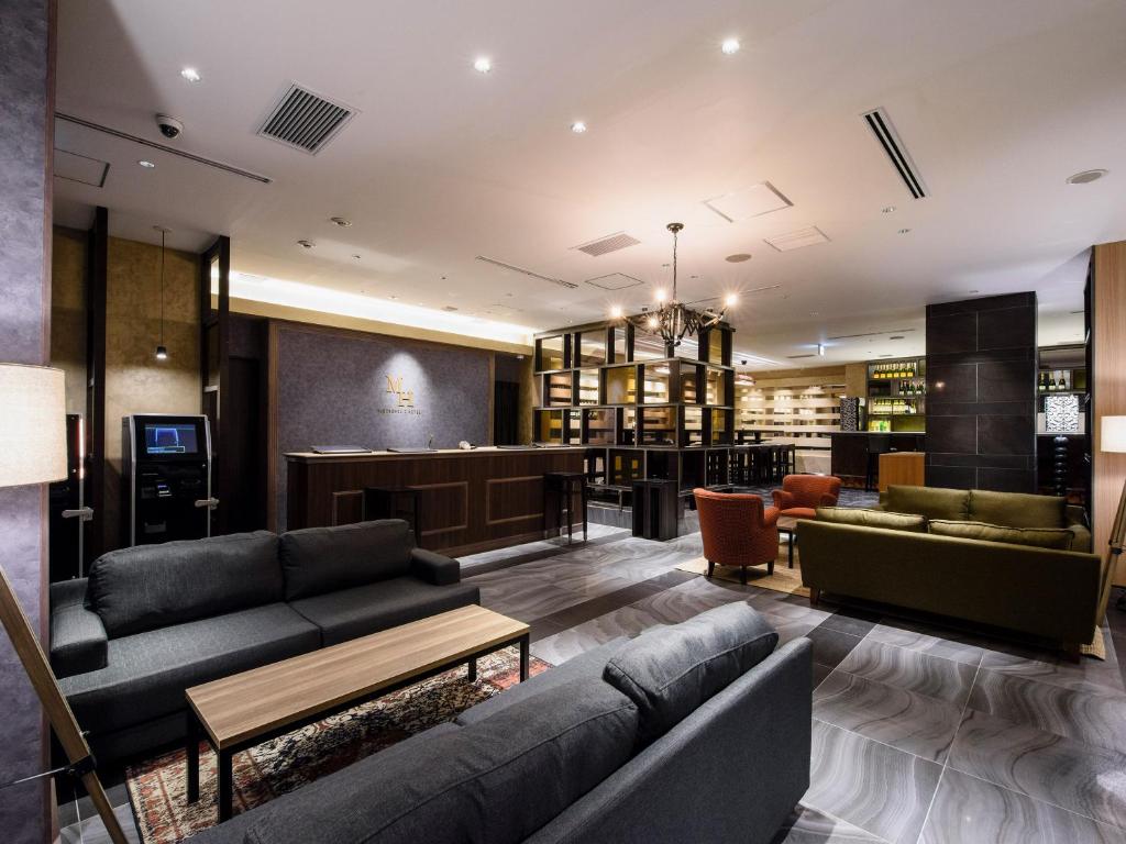 a lobby with couches and a bar in a building at Meguroholic Hotel in Tokyo