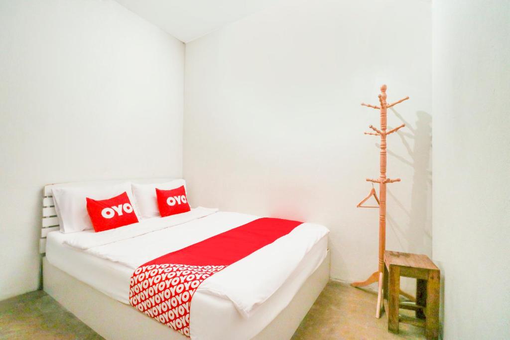 1 dormitorio con 1 cama con almohadas rojas y blancas en OYO 688 Bangkok Hub Hostel, en Bangkok