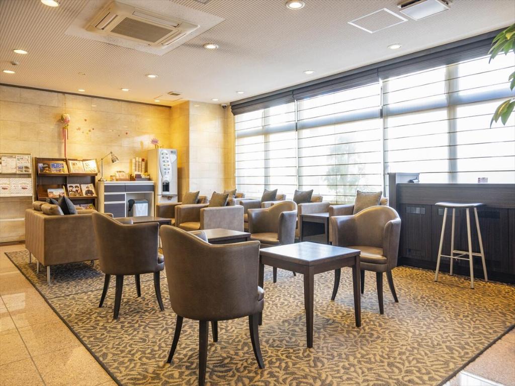 a waiting room with chairs and tables and a bar at Nishitetsu Inn Tenjin in Fukuoka