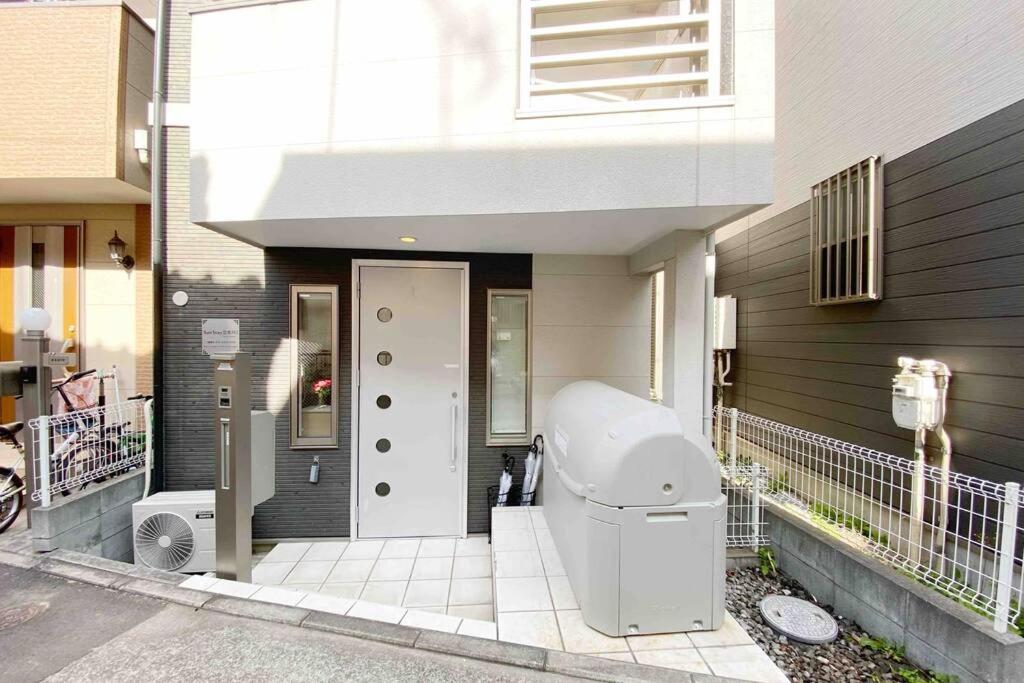 biała toaleta siedząca na zewnątrz domu w obiekcie SunStay - Tachiaigawa 1 w Tokio