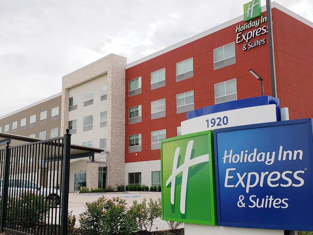 ein Urlaubsgasthof Express und Suiten vor einem Gebäude unterzeichnen in der Unterkunft Holiday Inn Express & Suites - Houston IAH - Beltway 8, an IHG Hotel in Houston