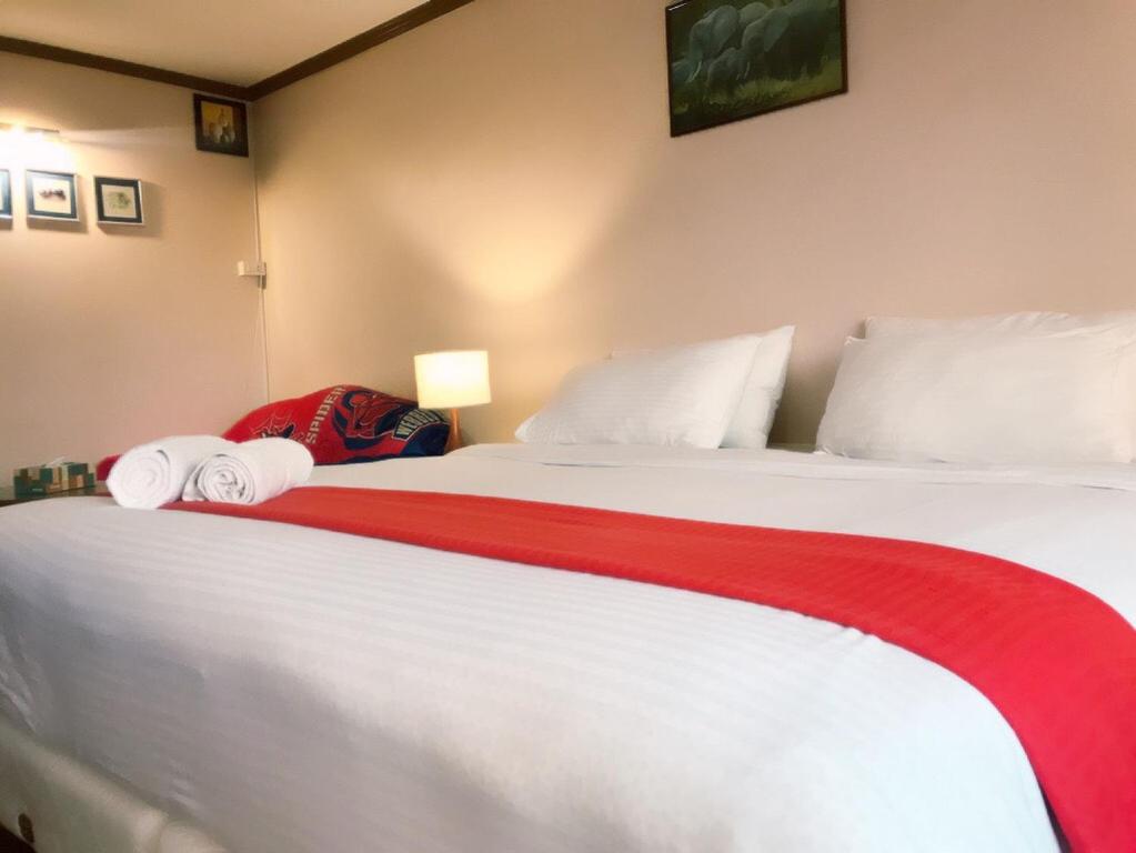 a bedroom with two beds with red and white sheets at Omni Tower Cozy Apartment Nana BTS in Bangkok