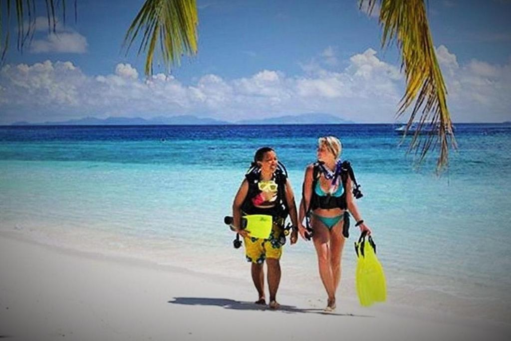 two women are walking on the beach at Devocean Eco Adventure Lodge in Ponta do Ouro