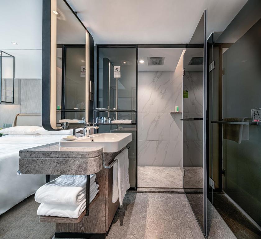 a bathroom with a sink and a shower at Hotel Landmark Canton in Guangzhou