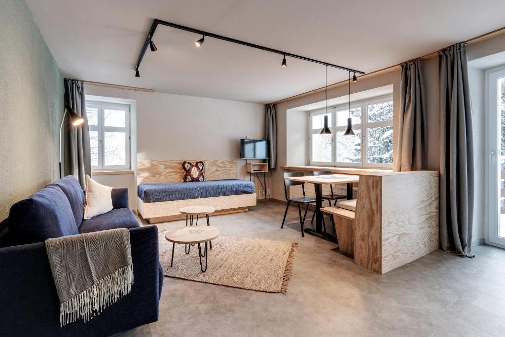 een woonkamer met een bank en een tafel bij Belmont- Apartment Haus in Arosa