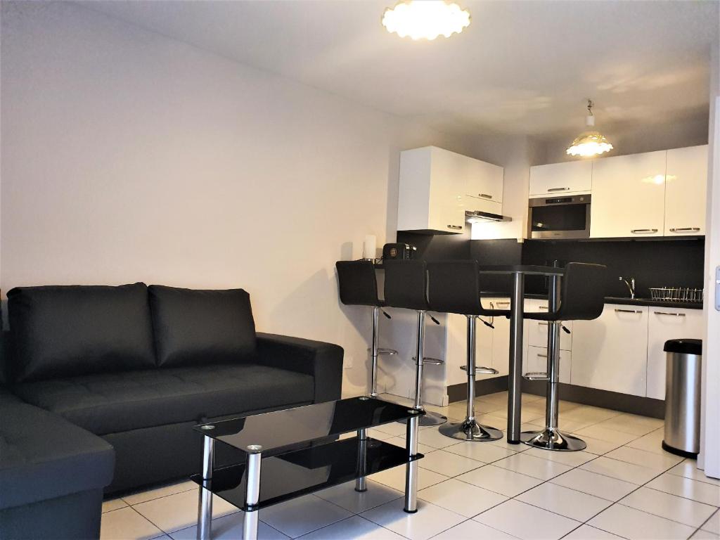 un salon avec un canapé noir et une cuisine dans l'établissement Palazzio 2, by Welcome to Cannes, à Cannes