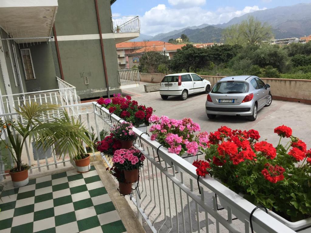 two cars parked in a parking lot with flowers at Casa Sweet-lama in Calatabiano
