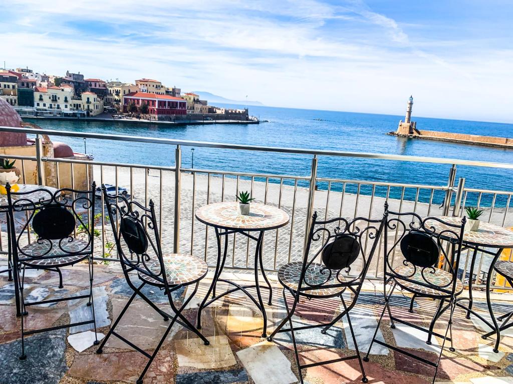 a table and chairs on a balcony overlooking the ocean at Amphitrite Hotel in Chania