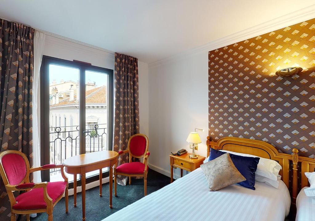 une chambre d'hôtel avec un lit, une table et des chaises dans l'établissement Sun Riviera Hotel, à Cannes