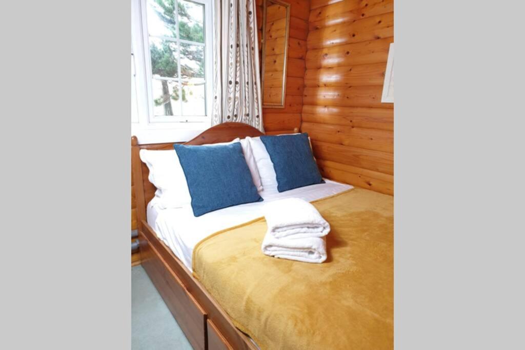 1 cama en una cabaña de madera con ventana en Country log cabin By Seren Property en Trawsfynydd
