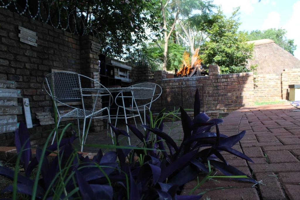 a metal chair sitting next to a brick wall at Bottie's Rock in Pretoria