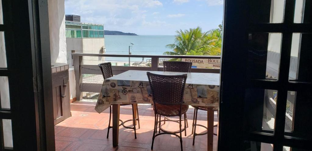 una mesa y sillas en un balcón con vistas al océano en Apartamento com Vista ao Mar, en Bombinhas