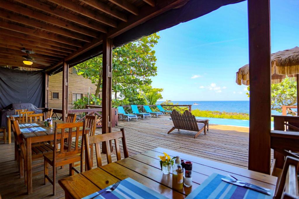 a restaurant with a view of the ocean from the deck at Cocolobo Resort in West End
