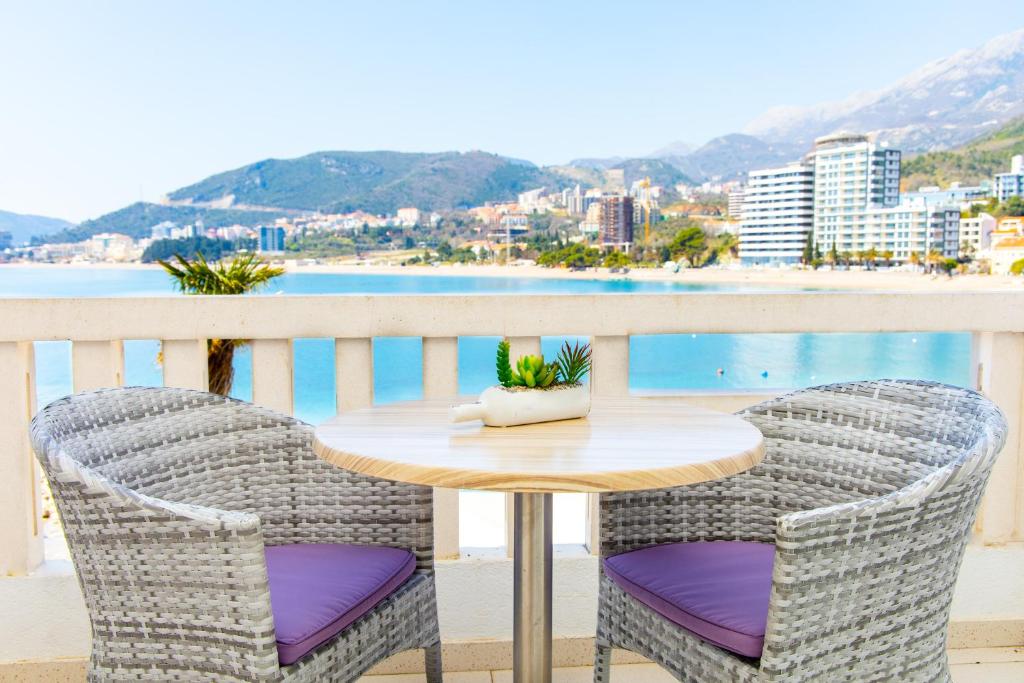 a table and chairs on a balcony with a view of the ocean at Ponta in Rafailovici