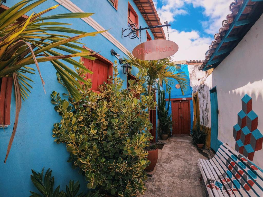 Une allée avec des plantes et un bâtiment bleu dans l'établissement Viela Hostel, à Lençóis