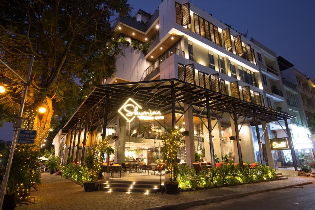 a building with a restaurant in front of it at night at Orchid Boutique Hotel & Apartment in Ho Chi Minh City