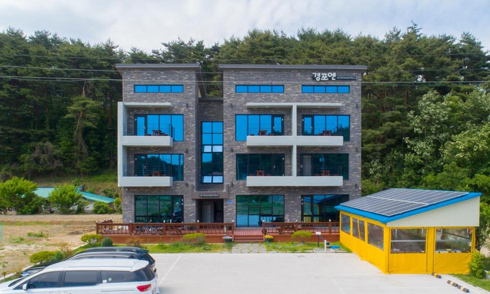 un edificio con un estacionamiento delante de él en Gyeongpoen Pension, en Gangneung