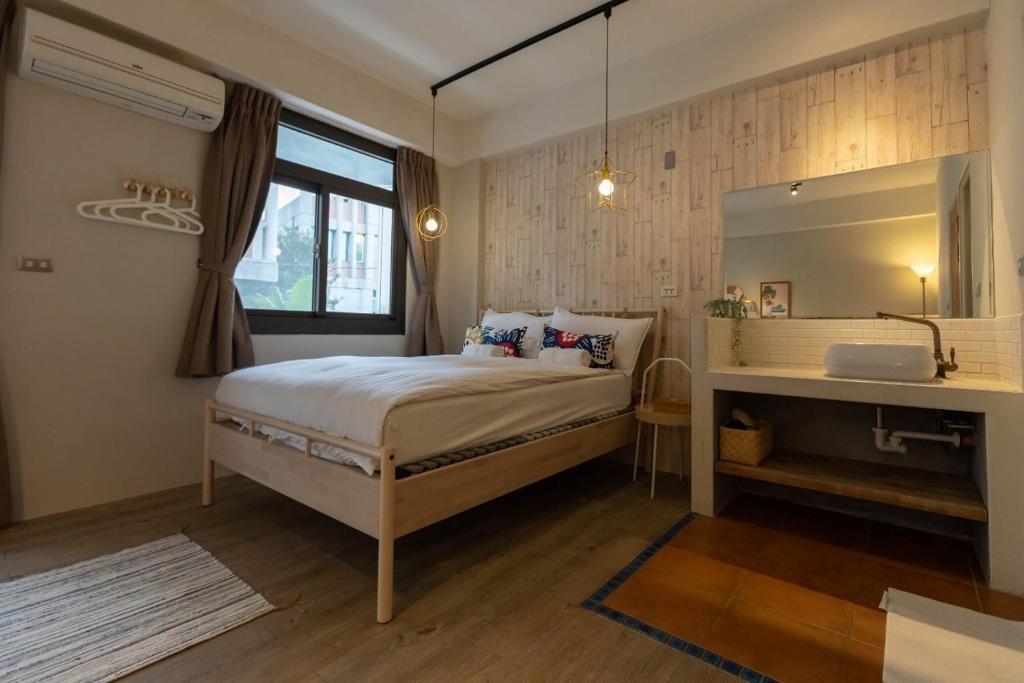 a bedroom with a bed and a desk in it at Cozy House Hostel in Hualien City