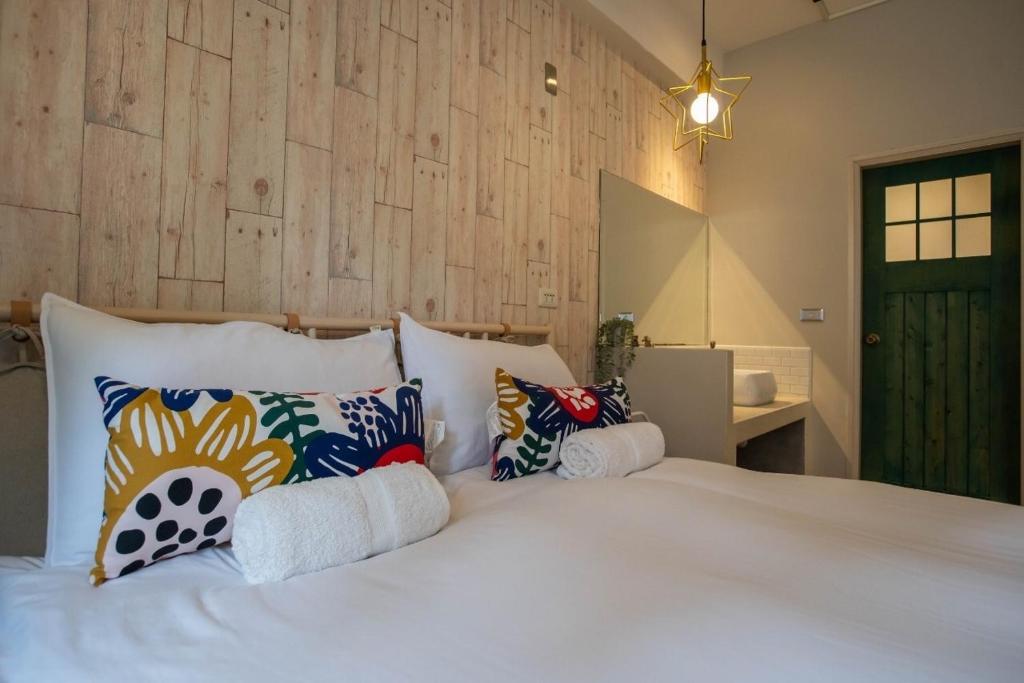 a bedroom with a large white bed with pillows at Cozy House Hostel in Hualien City