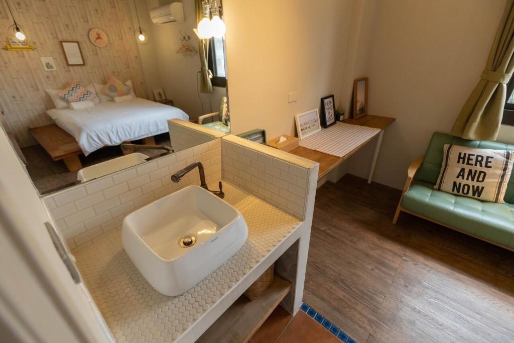 a bathroom with a sink in the middle of a room at Cozy House Hostel in Hualien City