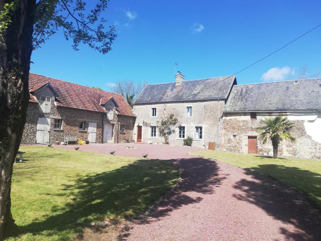 un grand bâtiment en pierre avec des oiseaux debout dans une allée. dans l'établissement Les Rivieres, à Saint-Germain-sur-Sèves