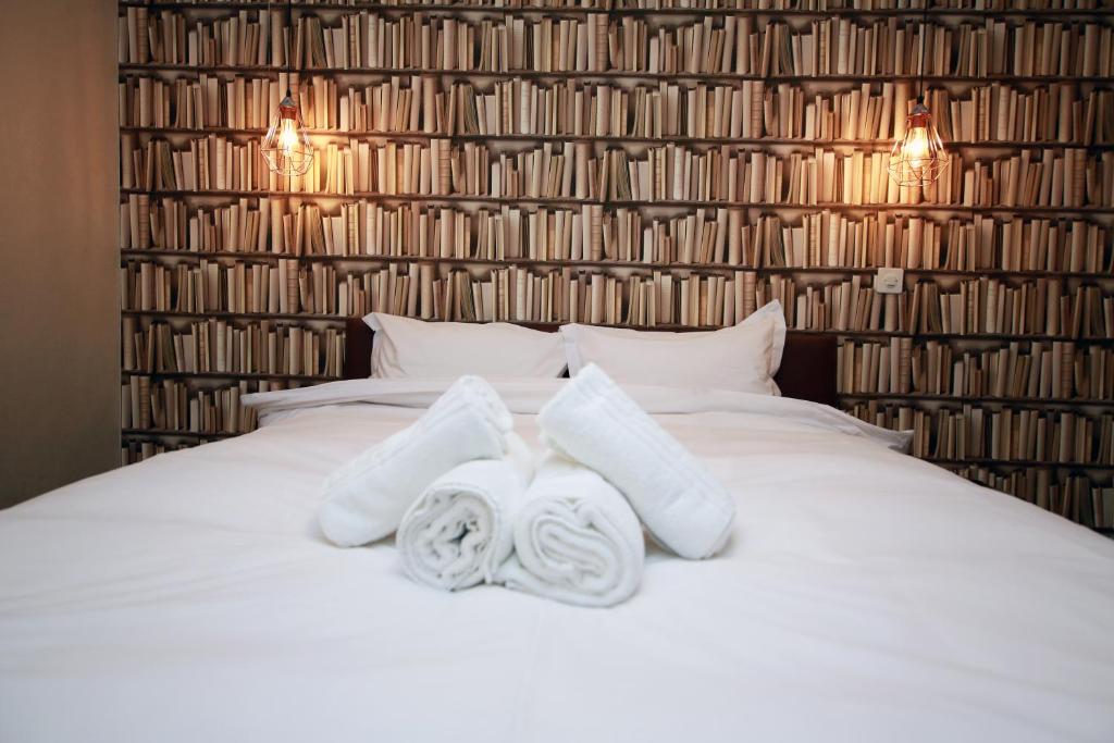 - une chambre avec un lit blanc et des serviettes dans l'établissement Cozy Apartment close to Cornavin Train Station and lake, à Genève