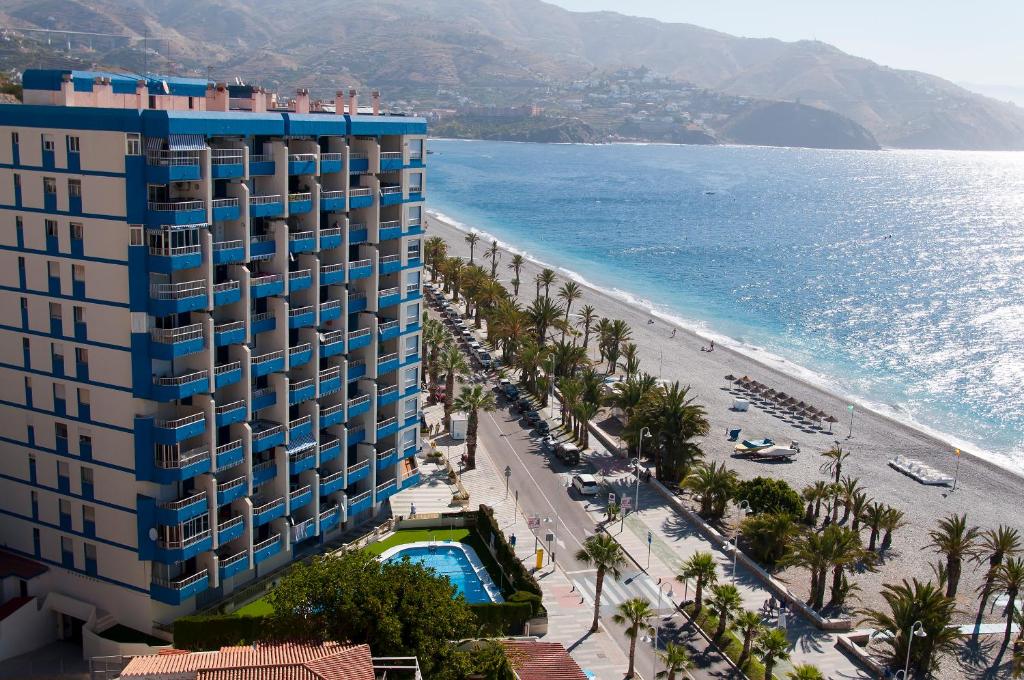 アルムニェーカルにあるApartamentos Taoのホテルとビーチの景色を望めます。