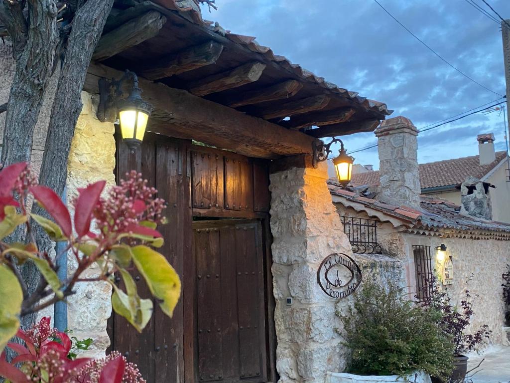 una casa con una puerta de madera y luces en ella en El Corral De Perorrubio, en Perorrubio