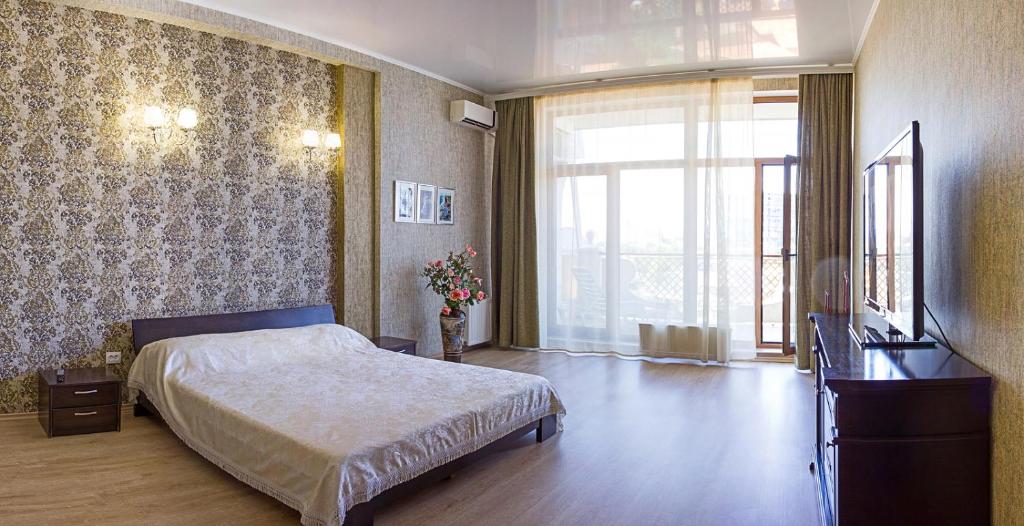 um quarto com uma cama, uma secretária e uma janela em Apartamenti u morya v Arkadii em Odessa