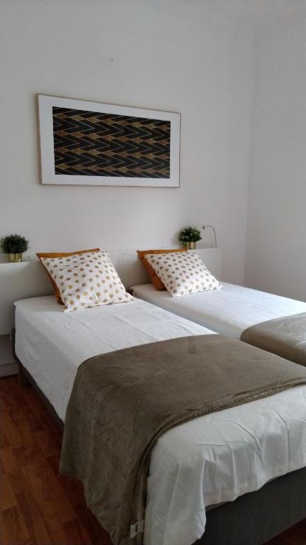 dos camas sentadas una al lado de la otra en una habitación en Tomarhousing - Garden en Tomar