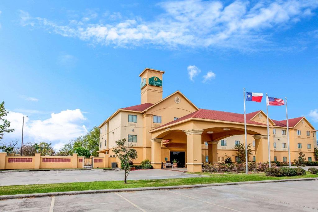 un edificio con una torre de reloj y dos banderas en La Quinta by Wyndham Pasadena, en Pasadena