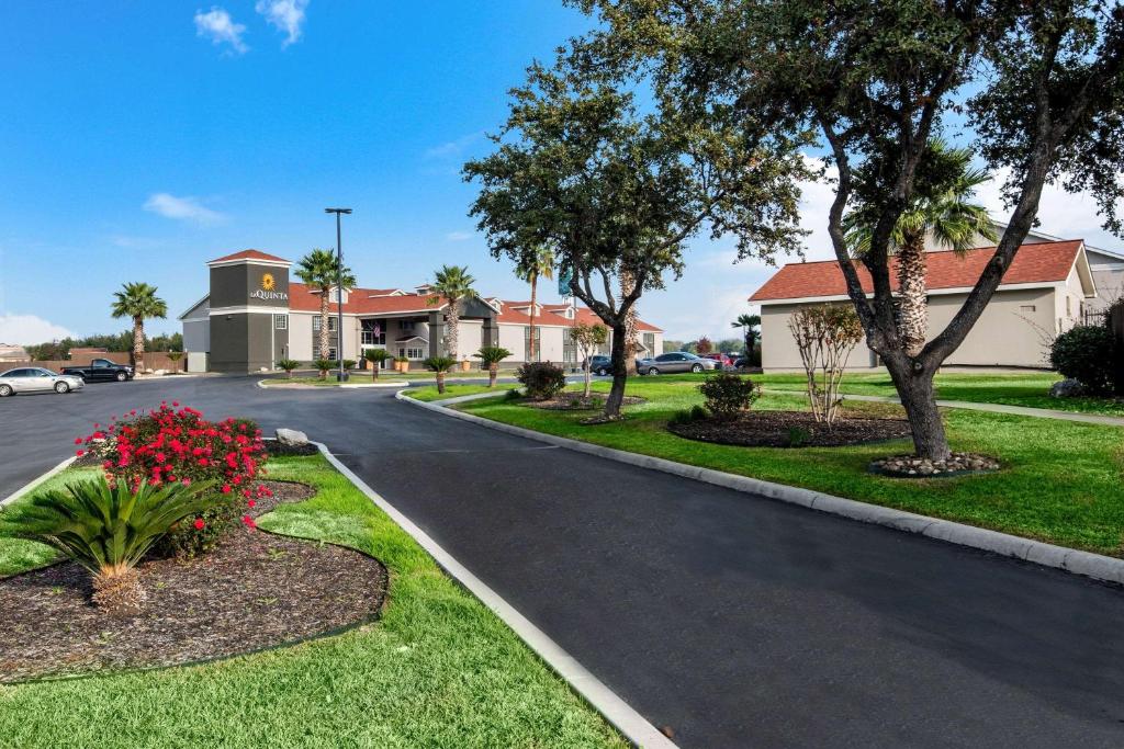 a street in a residential neighborhood with trees and flowers at La Quinta Inn by Wyndham San Antonio Brooks City Base in San Antonio