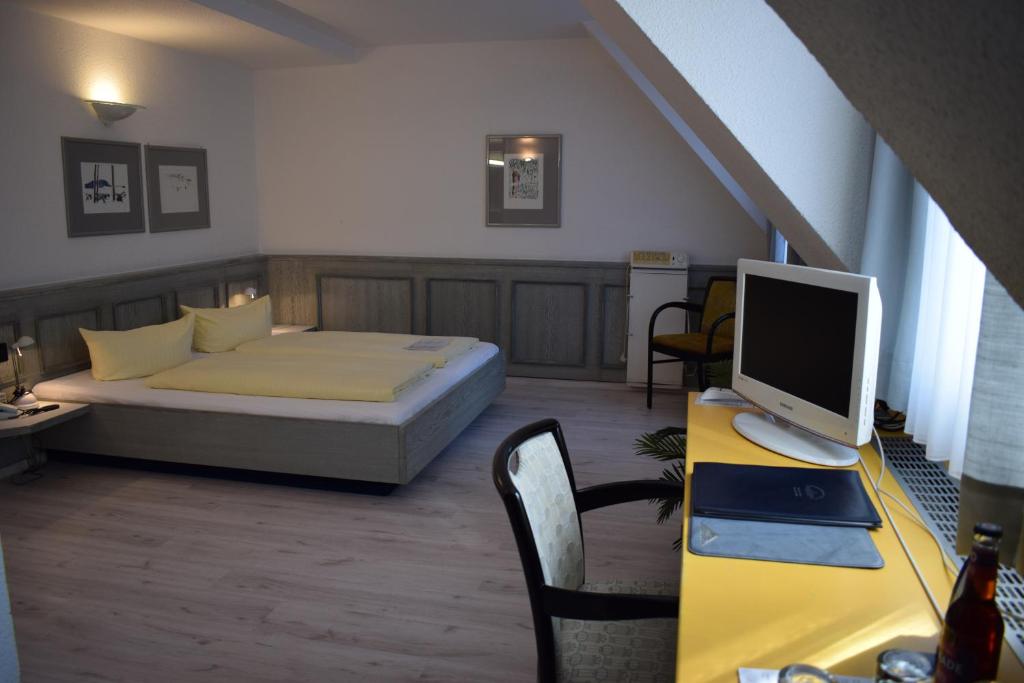 een slaapkamer met een bed en een bureau met een computer erop bij Avenue Hotel in Neurenberg
