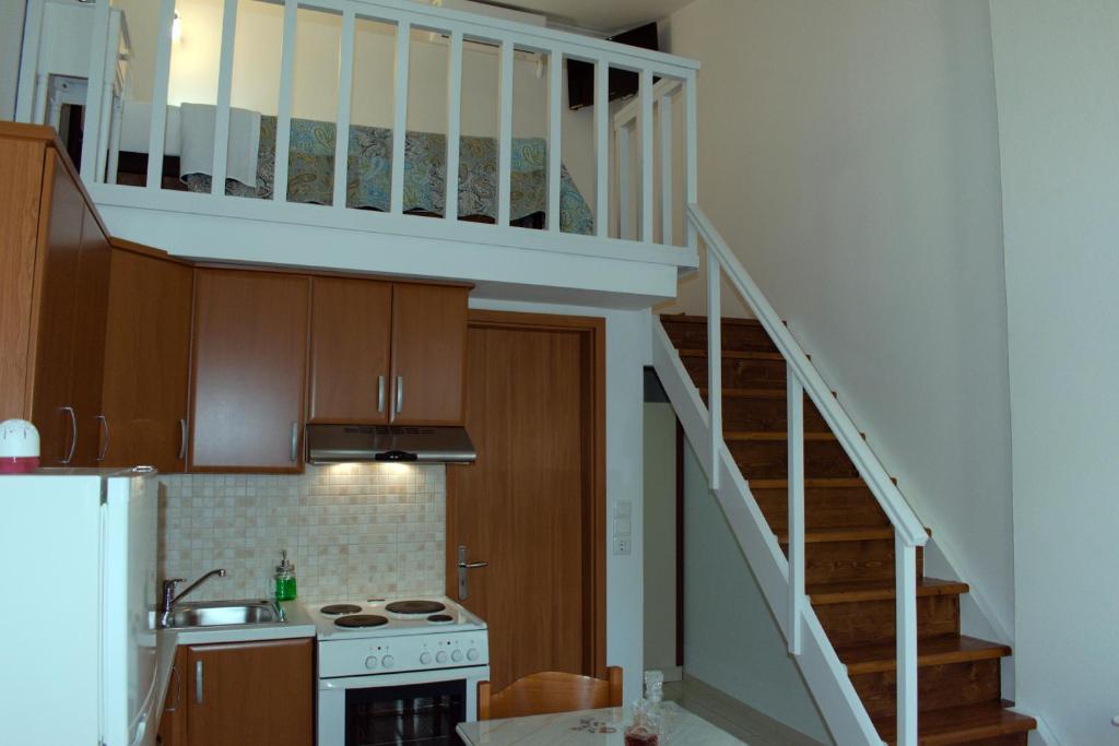 a kitchen with a staircase leading up to a loft at Preveli Apartments in Rethymno