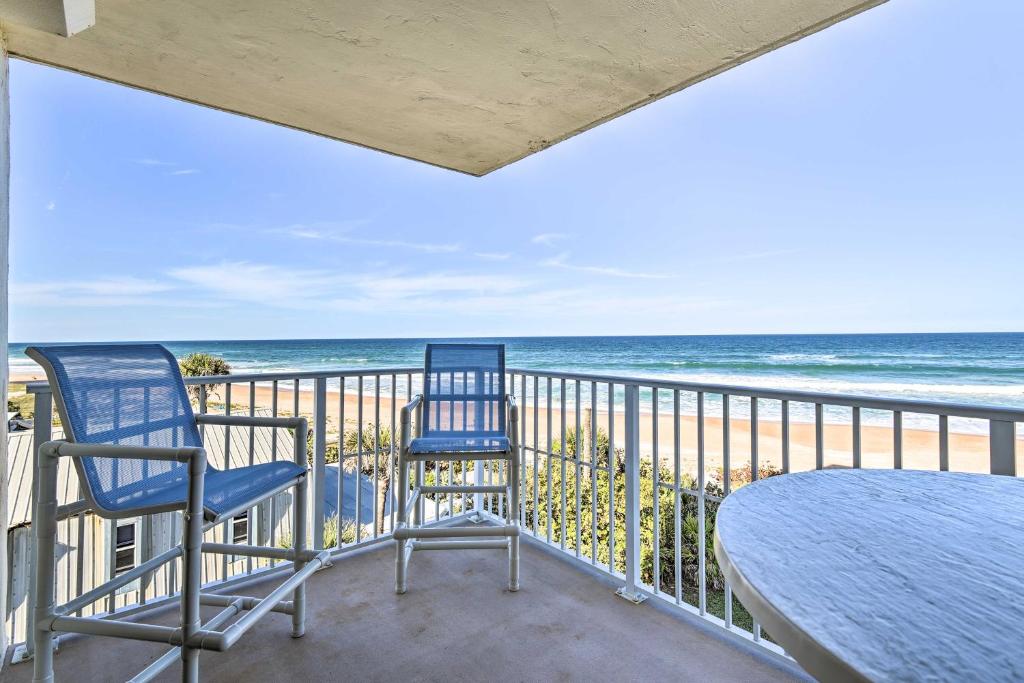 een balkon met 2 stoelen en een tafel en de oceaan bij Luxe Oceanfront Condo with Pool Beach Access and Gear in Ormond Beach