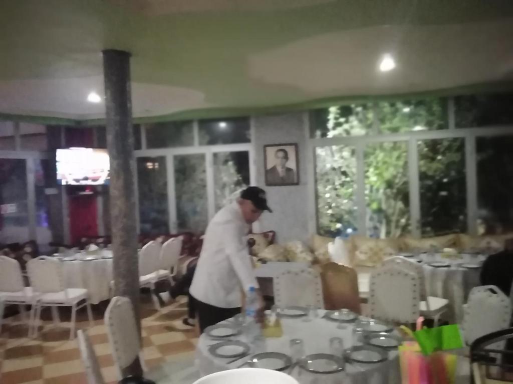 Un uomo in piedi davanti a un tavolo in un ristorante di reda land a Ben Slimane