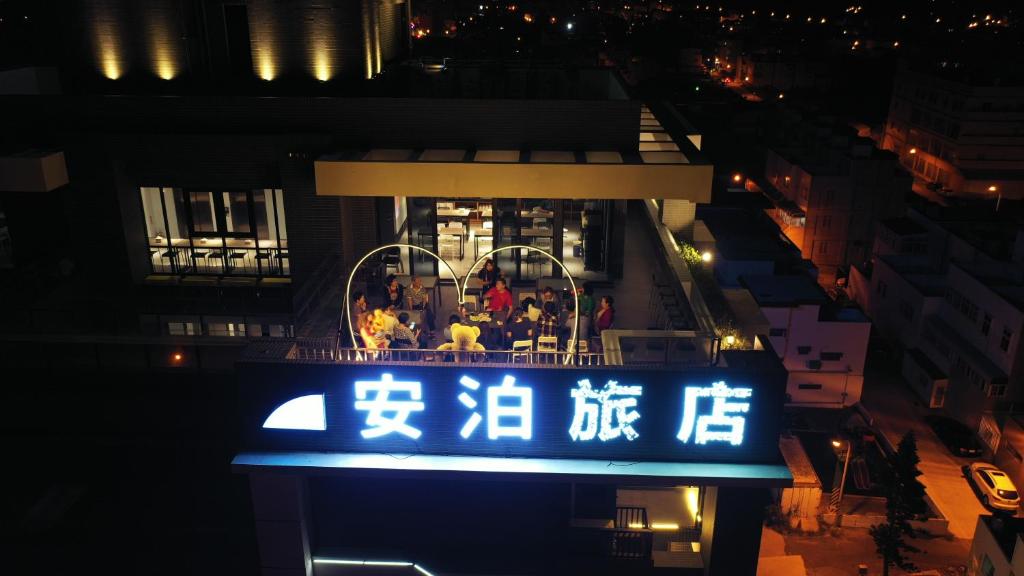 a sign for a restaurant in a city at night at Apause Hotel in Magong