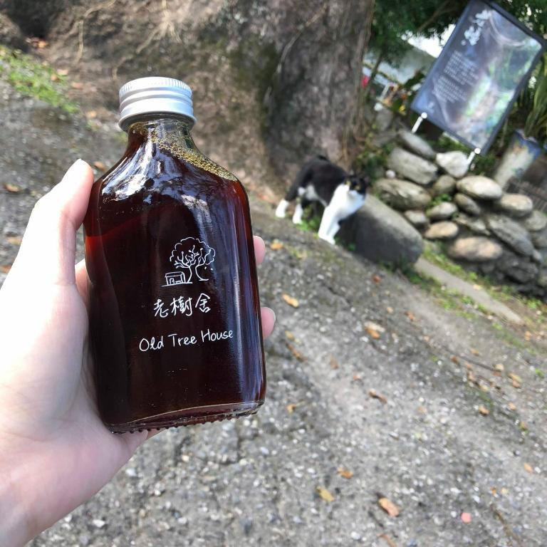 a person holding a bottle of oil tree sauce at Fangshuh B&amp;B in Fenglin