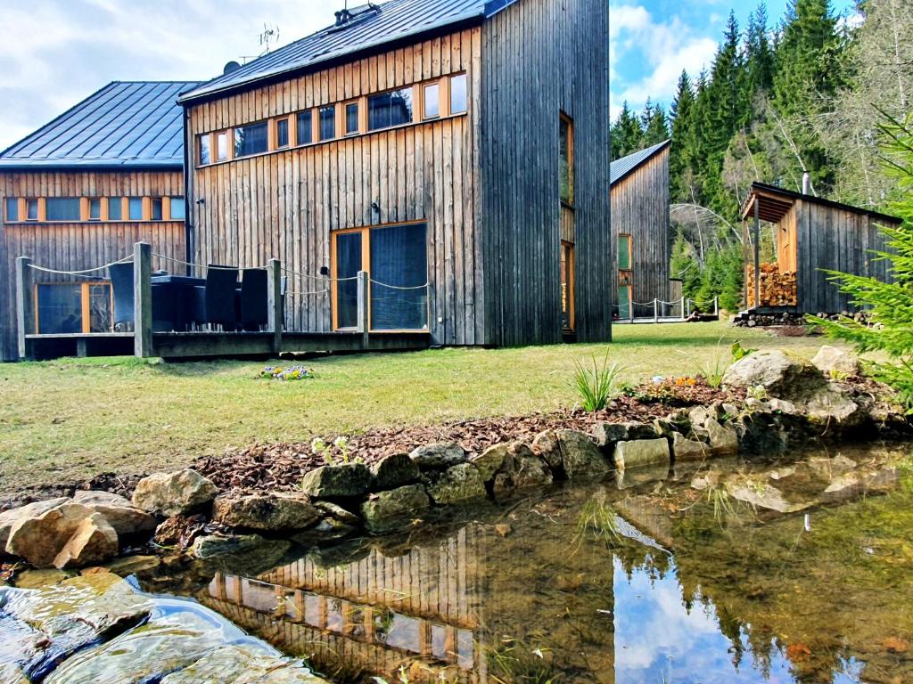 a barn next to a body of water at Naturepark Resort in Harrachov