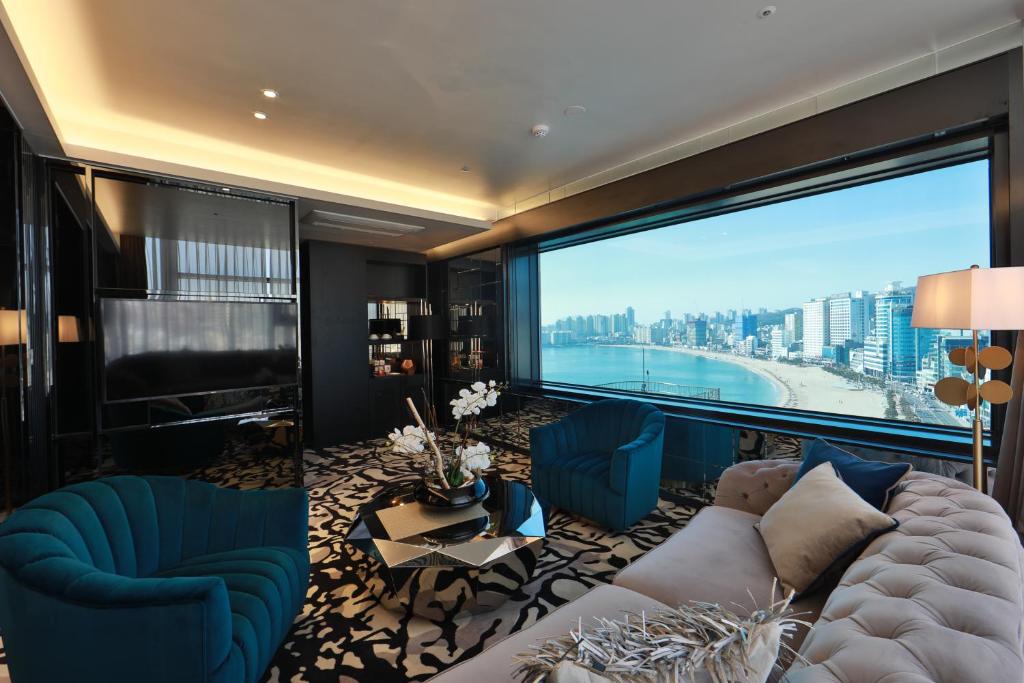 a living room with a couch and a large window at Best Louis Hamilton Hotel Gwangan in Busan