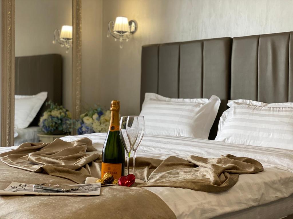 butelkę szampana i kieliszek na łóżku w obiekcie Apart Reserve Central w Iwano-Frankiwsku
