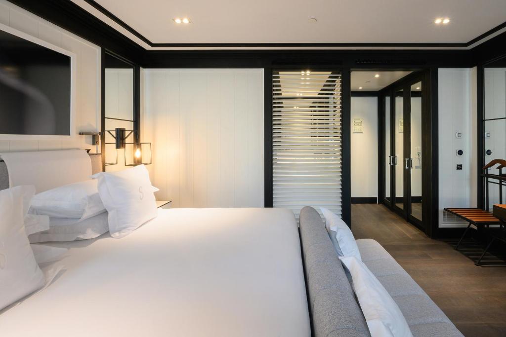 a bedroom with a large white bed and a table at Seventy Barcelona in Barcelona