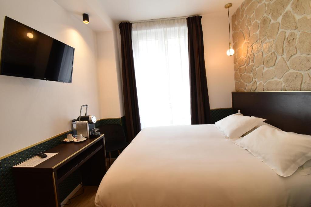 a hotel room with a bed and a television at Hôtel Bonne Nouvelle in Paris