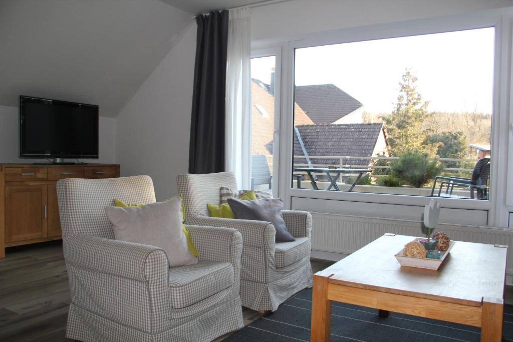 a living room with two chairs and a large window at Wohlfühlort in der Ferienresidenz Wurmbergblick in Braunlage