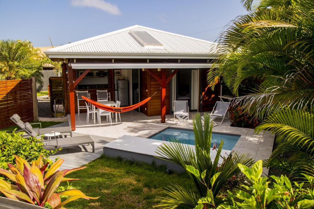 a house with a swimming pool in a yard at Fleurs de canne piscines privées in Le Moule