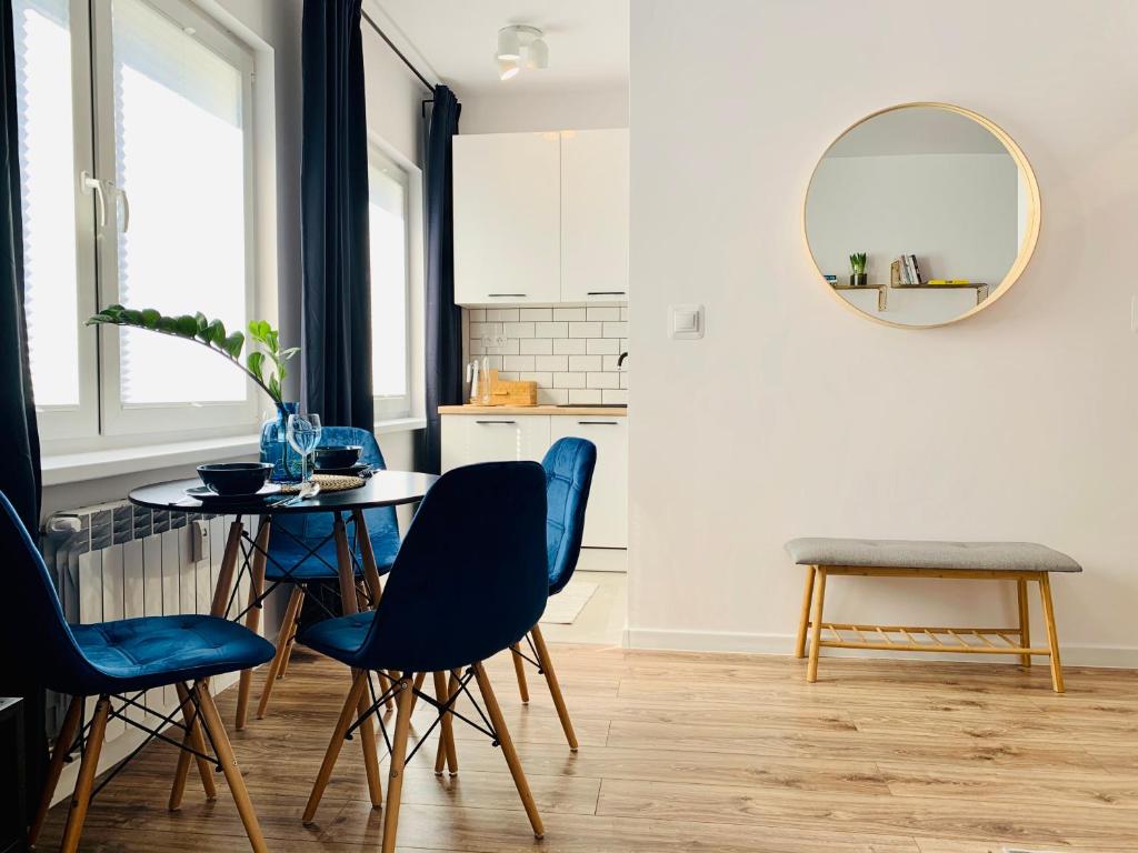 a kitchen with a table and chairs and a mirror at Apartament Niedźwiadek in Ustrzyki Dolne