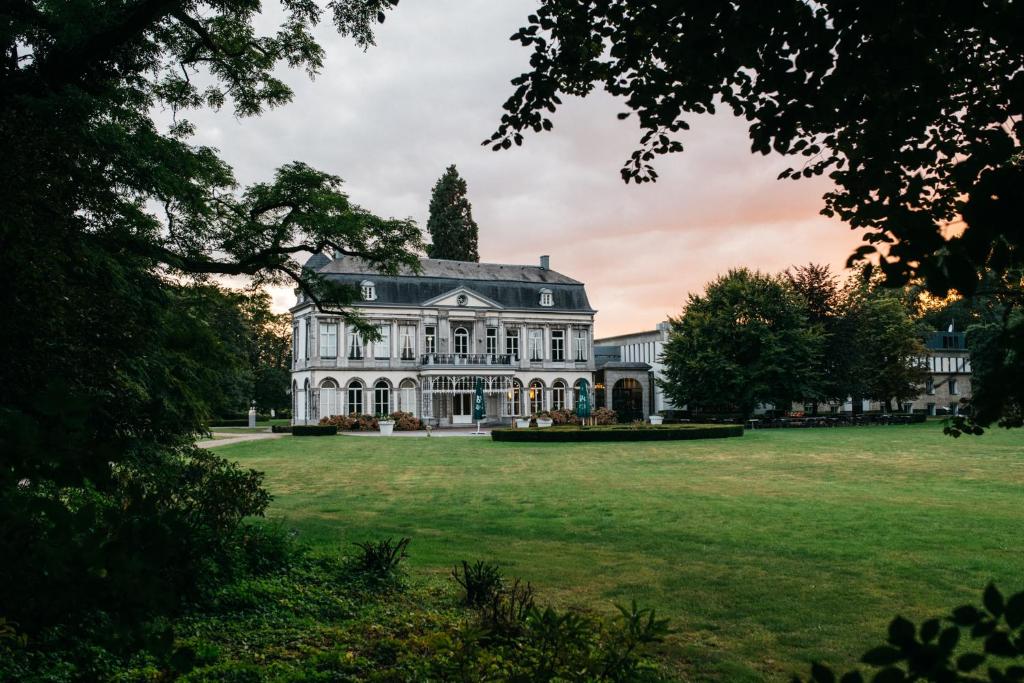 ein großes weißes Haus mit einem großen Hof in der Unterkunft Vaeshartelt Maastricht in Maastricht