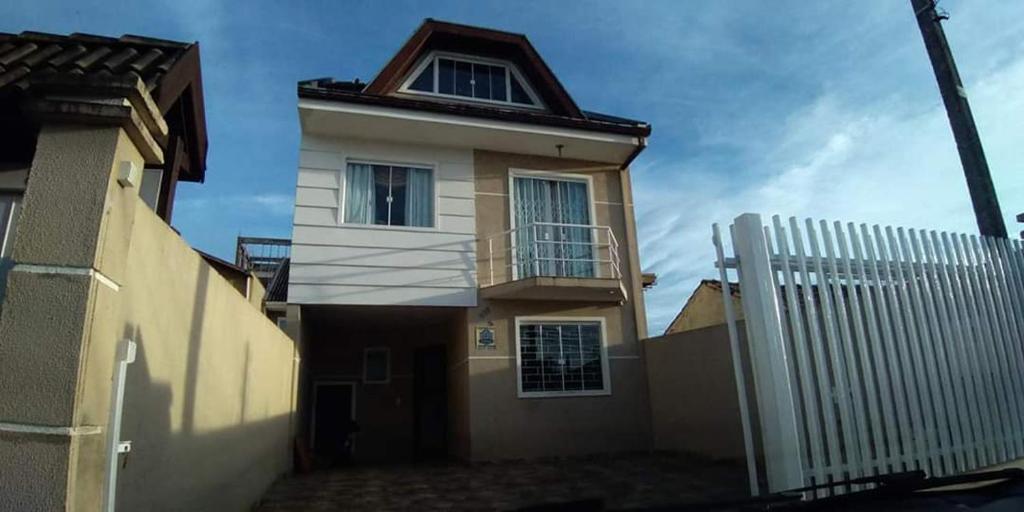 a house with a balcony and a fence at Casa Triplex Curitiba, Tingui, Bacacheri, Cindacta, Batalhão, Hospital Vita, Policia Federal, PF in Curitiba