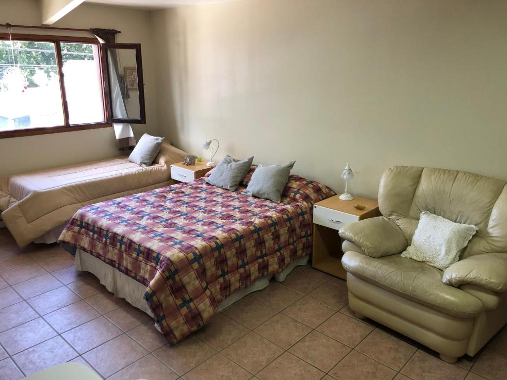 een slaapkamer met een bed, een bank en een stoel bij A un paso de todo !!! Lo de Richard in Ushuaia