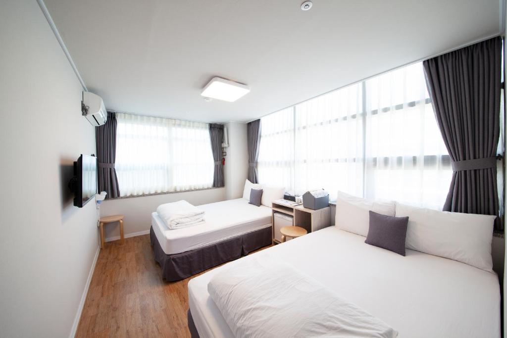 Habitación de hotel con 2 camas y ventana en K-Grand Hostel Dongdaemun en Seúl